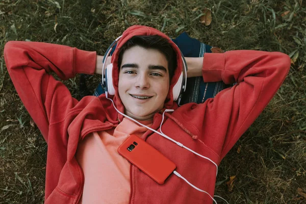 Jovem Adolescente Sexo Masculino Com Fones Ouvido Telefone Deitado Campo — Fotografia de Stock