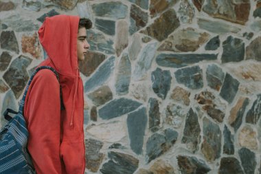 Okul çantası ve arka duvarı olan moda öğrencisi.