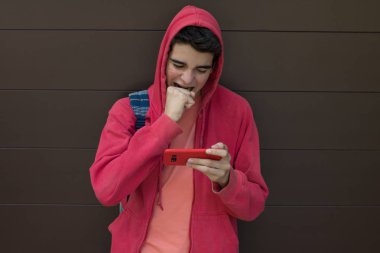 Öfke ifadesi ve cep telefonuyla öfke dolu genç bir öğrenci.