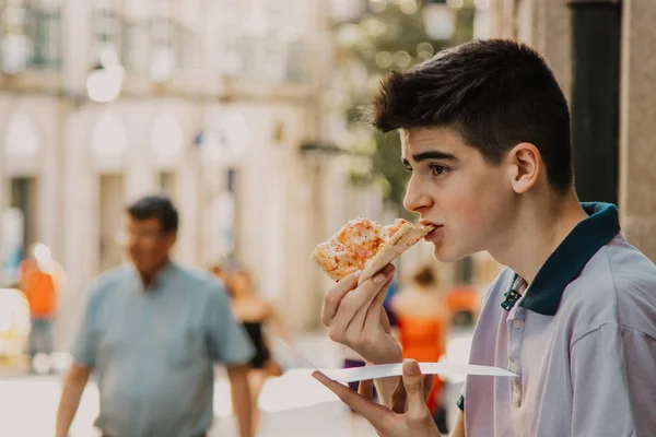 Νεαρός Άνδρας Τρώει Πίτσα Στο Δρόμο Της Πόλης — Φωτογραφία Αρχείου