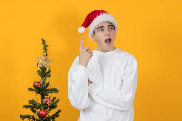 Noel Baba Şapkalı Genç Bir Adam Renkli Bir Noel Ağacı — Stok fotoğraf