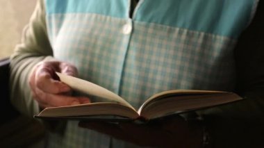 Pencere kenarında kitap okuyan son sınıf öğrencisi kadın.