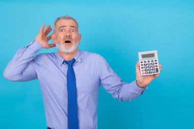 Hesap makinesi olan iş adamı arka planda stresli ve izole