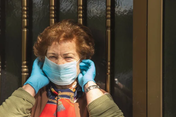 Eldivenli Maskeli Yaşlı Kadın Kapıdaki Salgından Korunuyor — Stok fotoğraf