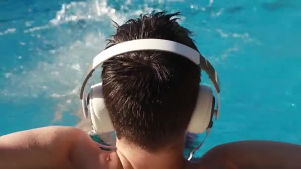 Młody Człowiek Basenie Słuchawkami Słuchającymi Muzyki — Wideo stockowe