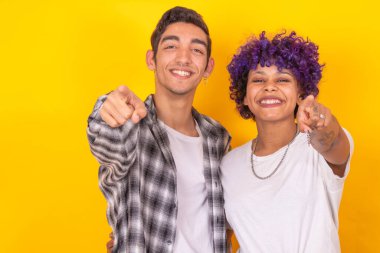 Renkli arka planda izole edilmiş genç erkek ve kadın çifti