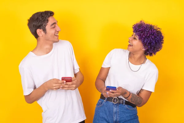 smiling young couple with mobile phones isolated on background