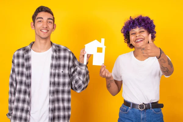 young couple with house isolated on color background