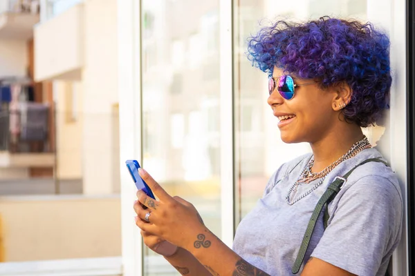 girl with afro american latin phone and sunglasses outdoors in the city