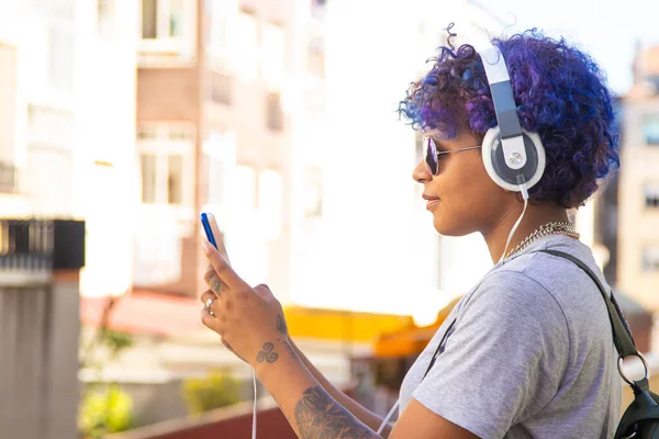 girl with phone and headphones outdoors in the city