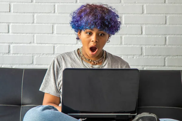 stock image young woman at home with laptop sitting on the living room sofa