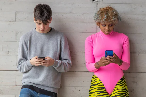 multiethnic young couple with mobile phone on the street