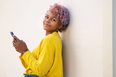 Sokaktaki cep telefonlu Afro-Amerikan kızın portresi.