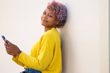 Sokaktaki cep telefonlu Afro-Amerikan kızın portresi.