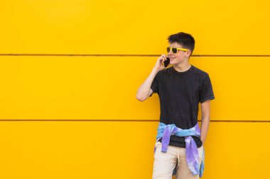 Sokakta cep telefonu olan genç bir çocuk.