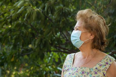 Yüz maskeli yaşlı bir kadının portresi.