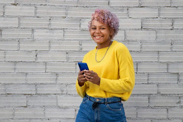 Sokakta cep telefonuyla gezen Afro-Amerikalı kız.