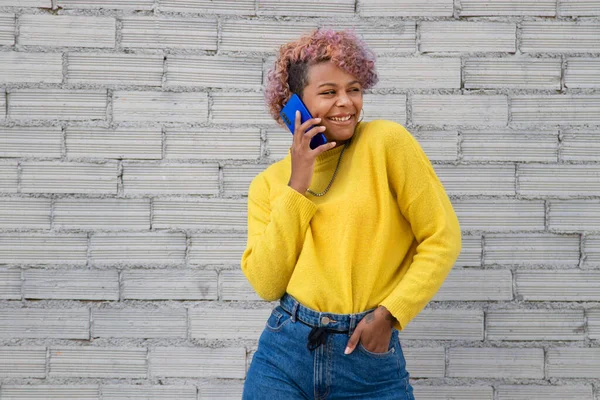 Sokakta cep telefonuyla gezen Afro-Amerikalı kız.