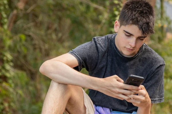 在户外带手机的年轻男性青少年 — 图库照片