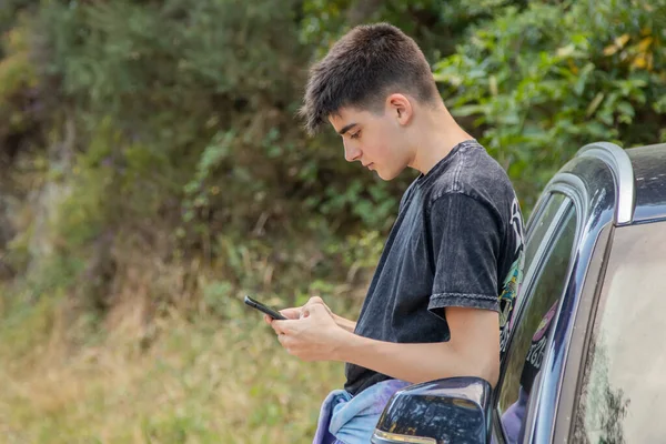 Młody Chłopiec Telefonem Komórkowym Samochodem Zewnątrz — Zdjęcie stockowe