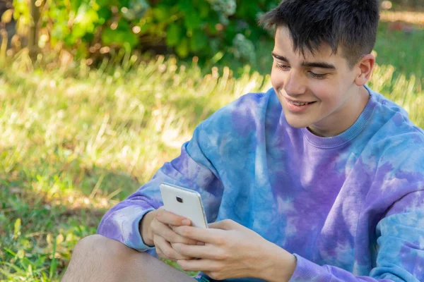 在户外带手机的年轻男性青少年 — 图库照片