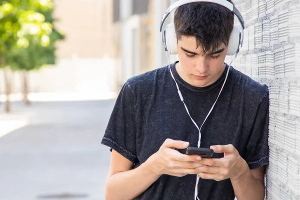 Έφηβος Αγόρι Κινητό Τηλέφωνο Και Ακουστικά Στο Δρόμο — Φωτογραφία Αρχείου