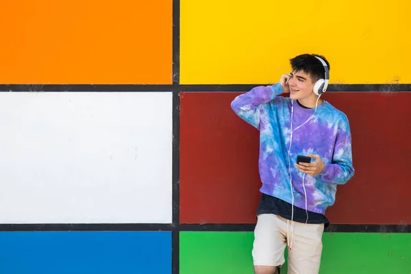 Jong Tiener Met Mobiele Telefoon Koptelefoon Kleurrijke Muur — Stockfoto