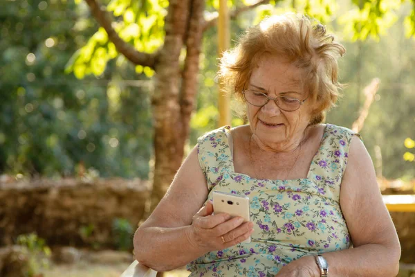 在户外带手机的老年妇女 — 图库照片