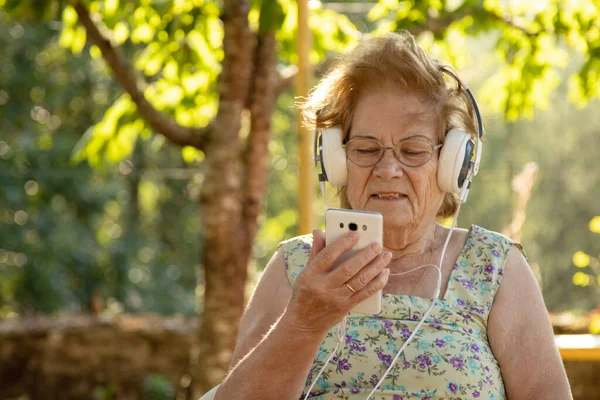 Пожилая Женщина Мобильным Телефоном Наушниками Открытом Воздухе — стоковое фото
