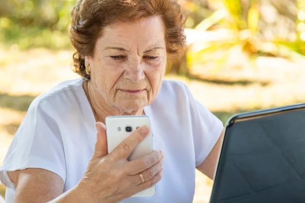 拥有移动电话和计算机的老年妇女 — 图库照片