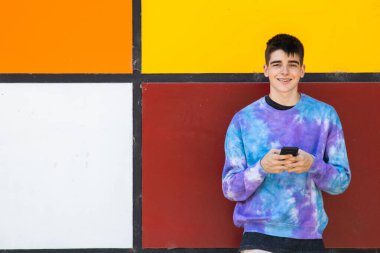 Cep telefonu olan genç bir çocuk.