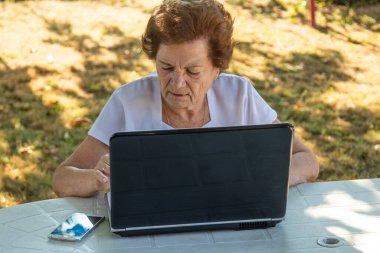 Bilgisayarla çalışan ya da öğrenen yaşlı kadın
