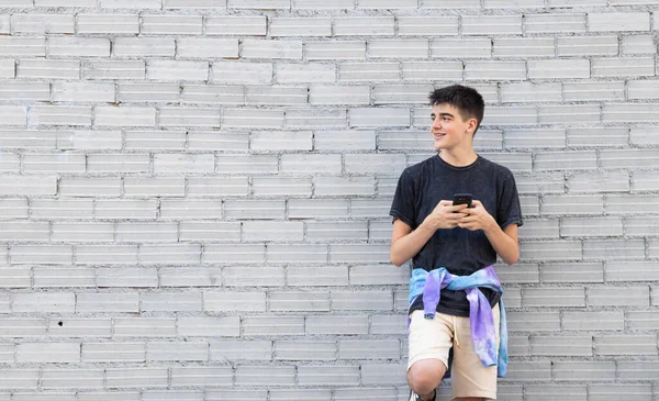 Adolescente Masculino Usando Smartphone Parede Tijolo Rua — Fotografia de Stock