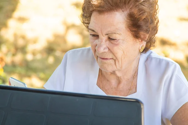 使用笔记本电脑工作或学习的老年妇女 — 图库照片