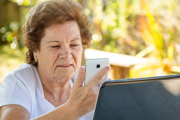 Senior Vrouw Met Mobiele Telefoon Computer Buiten — Stockfoto