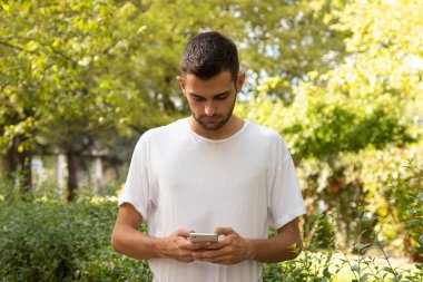 Dışarıda cep telefonu olan çekici bir genç adam.