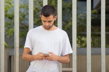 Sokakta cep telefonu olan çekici bir genç adam.