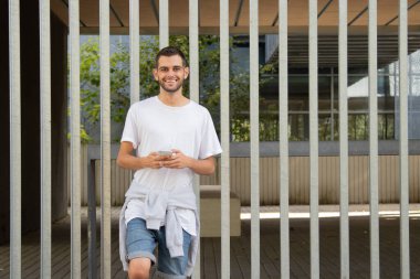 Sokakta cep telefonu olan çekici bir genç adam.