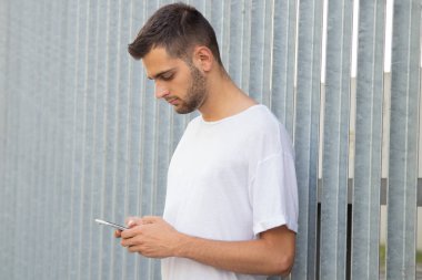 Sokakta cep telefonu olan çekici bir genç adam.