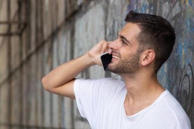 Sokakta cep telefonu olan genç bir adamın portresi.