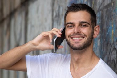 Sokakta cep telefonu olan genç bir adamın portresi.