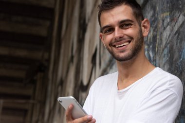 Sokakta cep telefonu olan genç bir adamın portresi.
