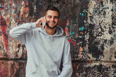 Sokakta cep telefonu olan genç bir adam.