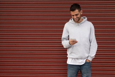 Garajda kör cep telefonu olan sıradan bir genç adam.