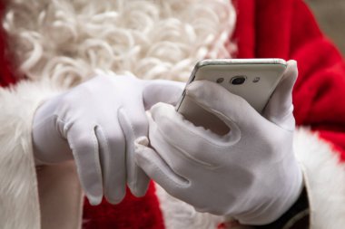Noel Baba 'nın cep telefonlu ellerine yakın çekim
