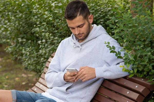 Jeune Homme Avec Téléphone Portable Dans Parc Assis — Photo
