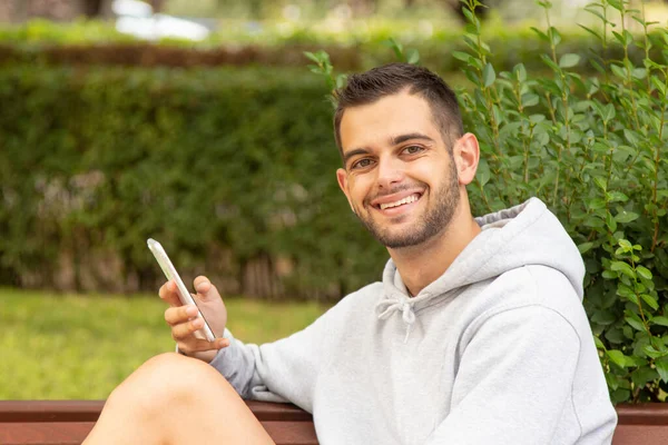 Attraente Giovane Uomo Con Barba Telefono Cellulare Seduto Nel Parco — Foto Stock