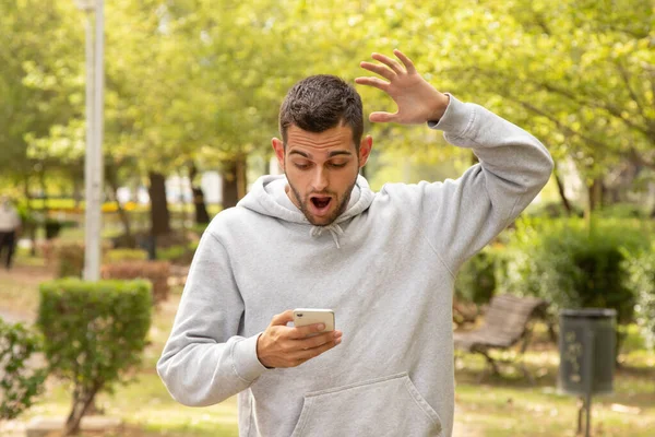 Aantrekkelijke Man Verrast Met Mobiele Telefoon Buiten — Stockfoto