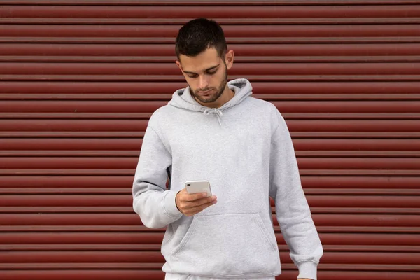 Stedelijke Jongeman Casual Stijl Met Mobiele Telefoon Garage Blind — Stockfoto