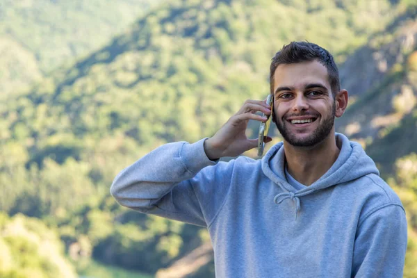 young man with mobile phone in nature outdoors